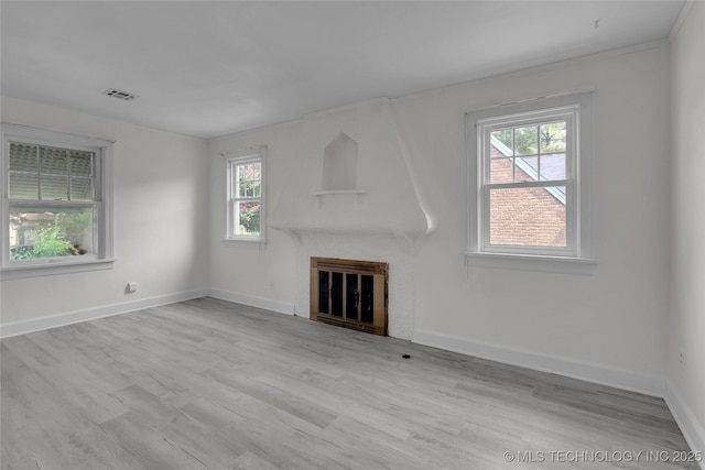 unfurnished living room with a wealth of natural light and light wood-type flooring