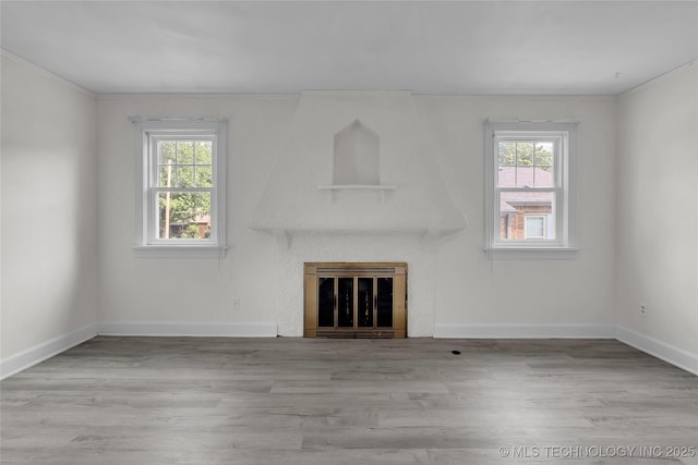 unfurnished living room with crown molding and light hardwood / wood-style floors