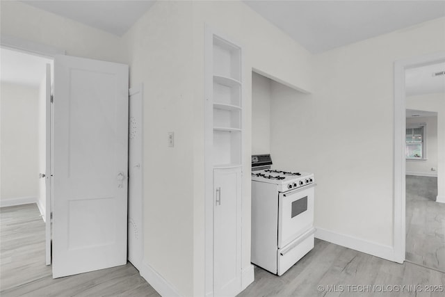 kitchen featuring white gas stove and light wood-type flooring