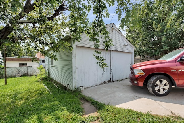 view of property exterior with a garage, a lawn, and an outdoor structure