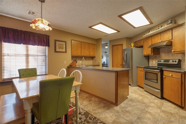 kitchen with stainless steel appliances, kitchen peninsula, decorative backsplash, and decorative light fixtures