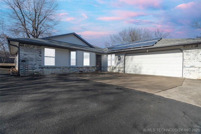 view of front of home with a garage and solar panels