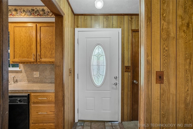 interior space with a textured ceiling and wood walls