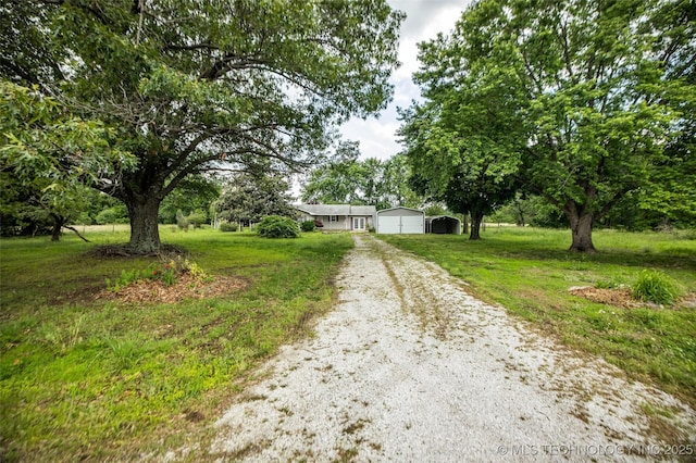 single story home with a garage, an outdoor structure, and a front lawn