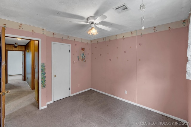 carpeted empty room featuring a textured ceiling and ceiling fan