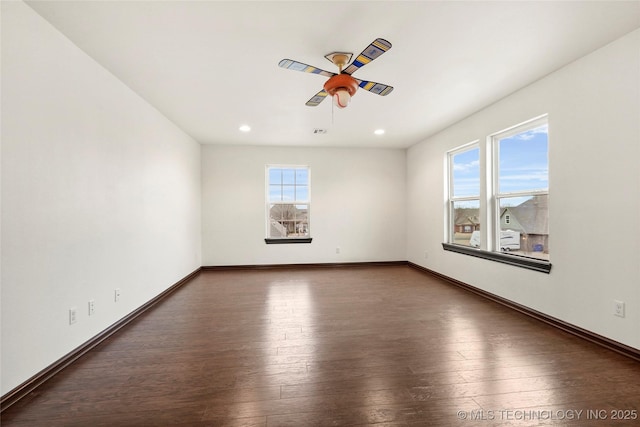 empty room with ceiling fan and dark hardwood / wood-style flooring