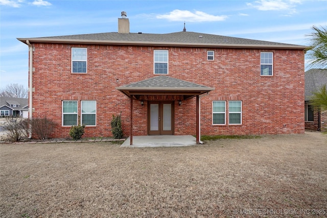 back of house featuring a lawn and a patio