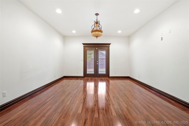 empty room with french doors and hardwood / wood-style floors