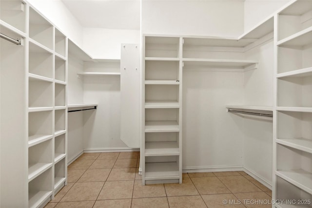 spacious closet with light tile patterned floors