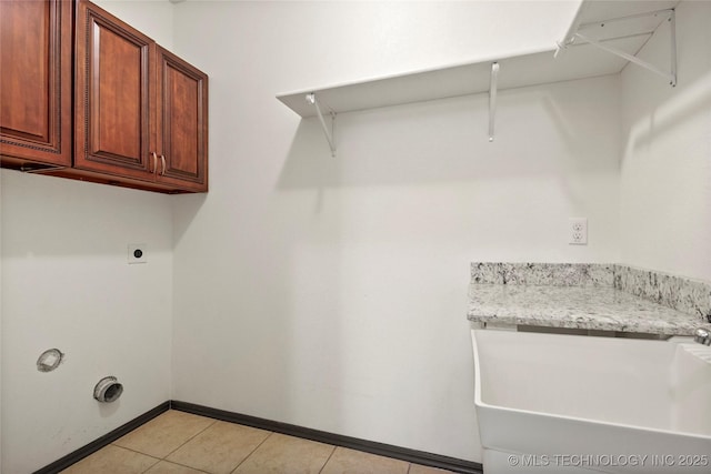 clothes washing area featuring cabinets, hookup for an electric dryer, and light tile patterned floors