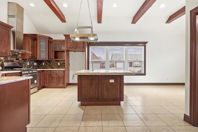 kitchen featuring wall chimney range hood, vaulted ceiling with beams, stainless steel gas range oven, decorative backsplash, and decorative light fixtures