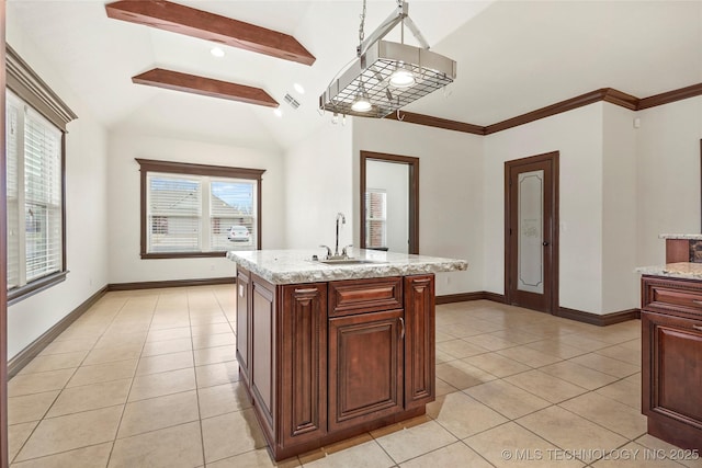 kitchen featuring a kitchen island with sink, sink, light stone countertops, and light tile patterned flooring