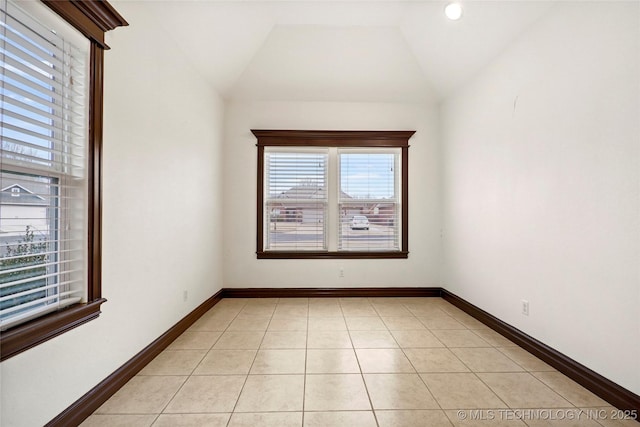 tiled spare room with vaulted ceiling