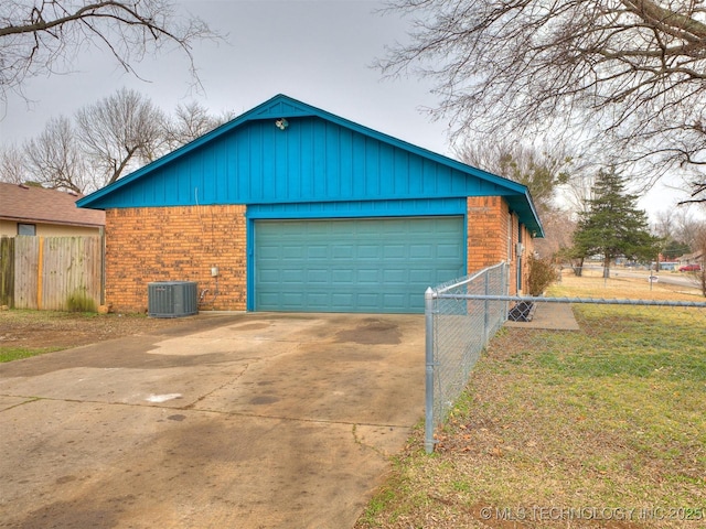 view of front facade with a garage, an outdoor structure, a front yard, and central AC unit