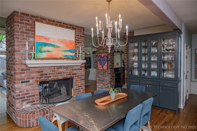 dining area with dark hardwood / wood-style floors, a chandelier, and a fireplace