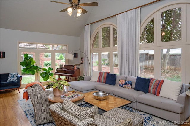 living room featuring hardwood / wood-style flooring, ceiling fan, and high vaulted ceiling