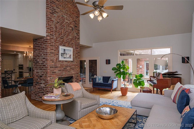 living room with ceiling fan, a fireplace, wood-type flooring, and a high ceiling