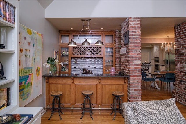 bar featuring hardwood / wood-style floors, decorative light fixtures, and a chandelier