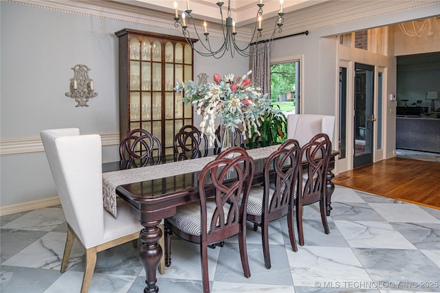 dining room with ornamental molding and a notable chandelier