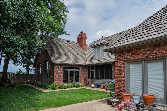 rear view of property with a lawn and a patio