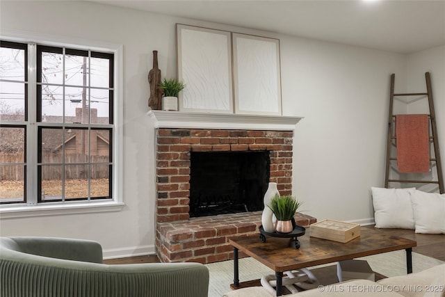 living room featuring hardwood / wood-style flooring, a fireplace, and a healthy amount of sunlight