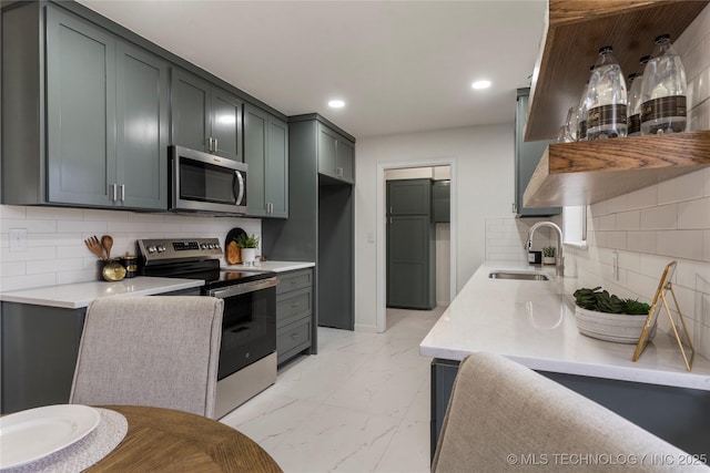 kitchen with appliances with stainless steel finishes, sink, and backsplash