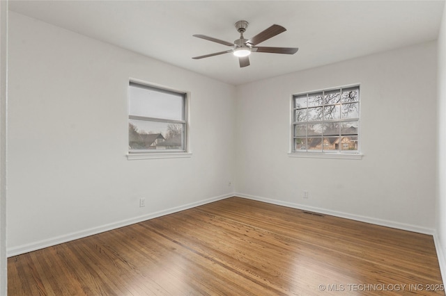 spare room featuring ceiling fan, plenty of natural light, and wood-type flooring