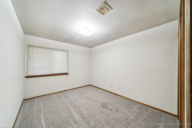 carpeted empty room featuring a textured ceiling