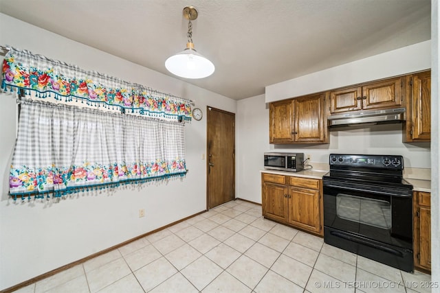 kitchen featuring black range with electric stovetop, light tile patterned floors, and decorative light fixtures