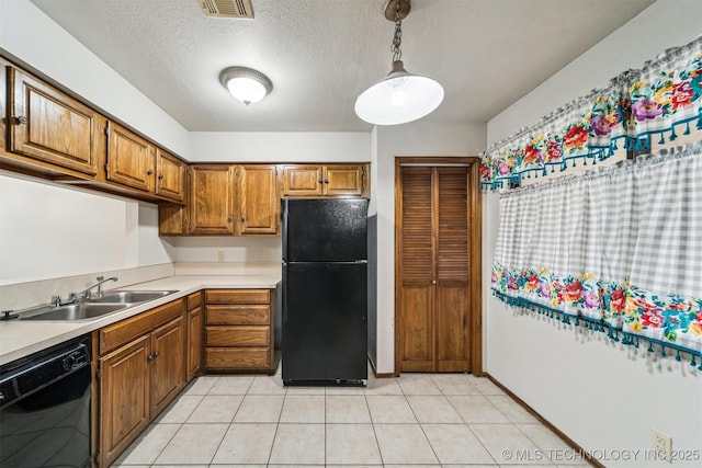 kitchen featuring pendant lighting, sink, black appliances, a textured ceiling, and light tile patterned flooring