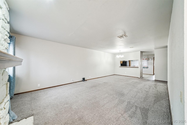 unfurnished living room with an inviting chandelier and carpet