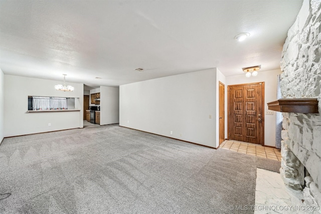 unfurnished living room with light colored carpet, a textured ceiling, and a notable chandelier