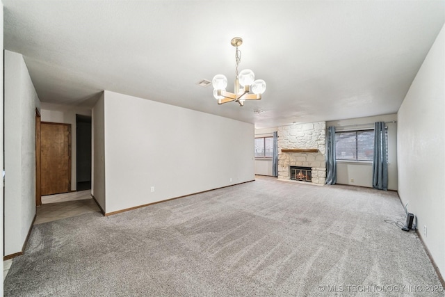 unfurnished living room featuring a fireplace, light carpet, and a notable chandelier