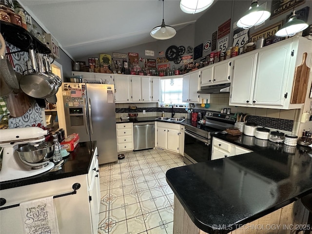 kitchen with lofted ceiling, sink, appliances with stainless steel finishes, white cabinetry, and backsplash