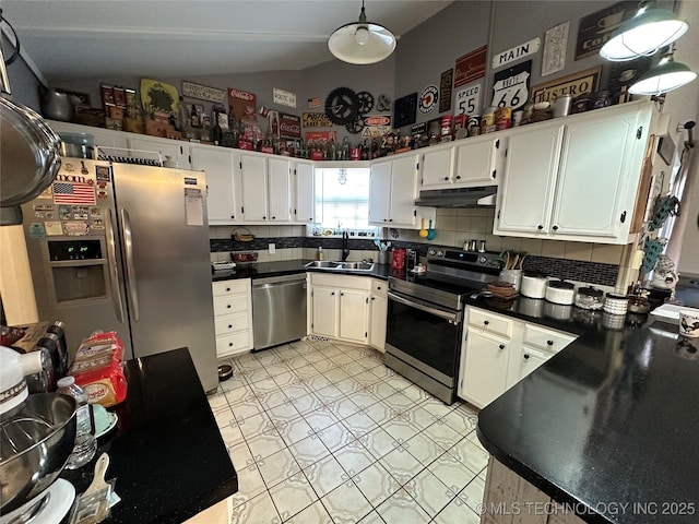 kitchen featuring vaulted ceiling, appliances with stainless steel finishes, tasteful backsplash, white cabinetry, and sink