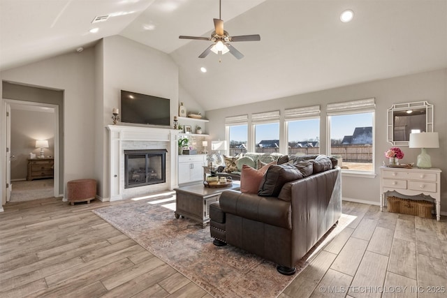 living room featuring high vaulted ceiling, light hardwood / wood-style floors, and ceiling fan