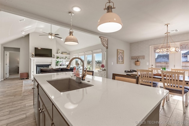 kitchen with a center island, sink, pendant lighting, and light hardwood / wood-style floors