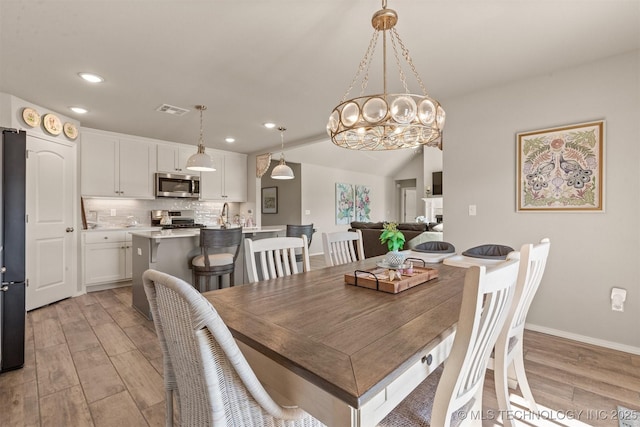 dining room featuring a notable chandelier and light hardwood / wood-style flooring