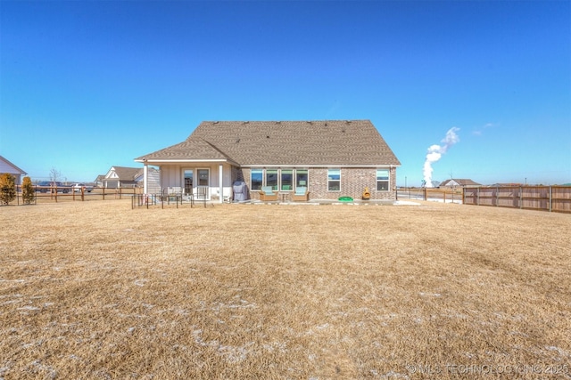 rear view of house with a patio and a lawn