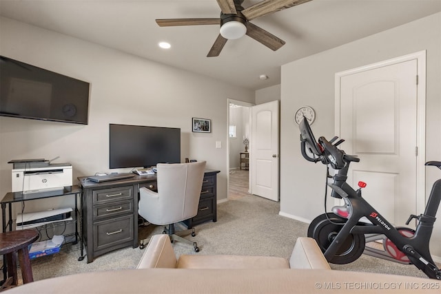 carpeted office featuring ceiling fan