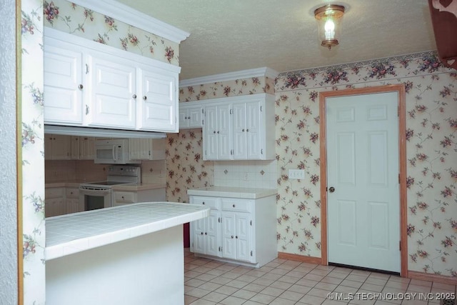 kitchen featuring light tile patterned floors, white appliances, tile counters, and white cabinets