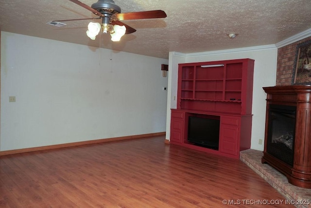 unfurnished living room featuring ceiling fan, hardwood / wood-style flooring, a fireplace, and a textured ceiling