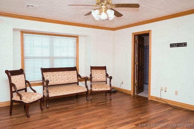 living area with dark wood-type flooring, ornamental molding, and ceiling fan