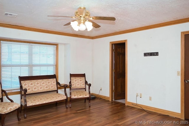 living area featuring crown molding, ceiling fan, dark hardwood / wood-style floors, and a textured ceiling