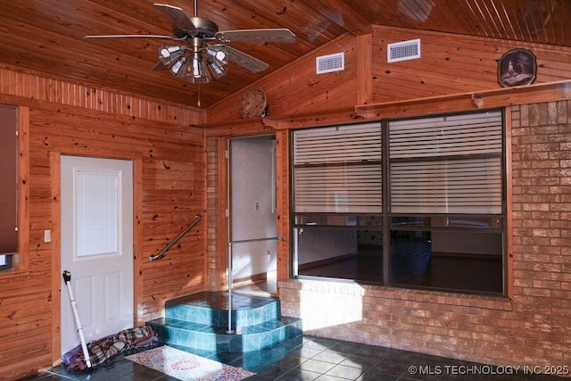 interior space featuring ceiling fan, lofted ceiling, wooden ceiling, and wood walls