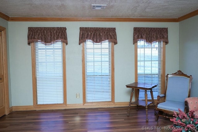 living area featuring ornamental molding, dark hardwood / wood-style floors, and a textured ceiling