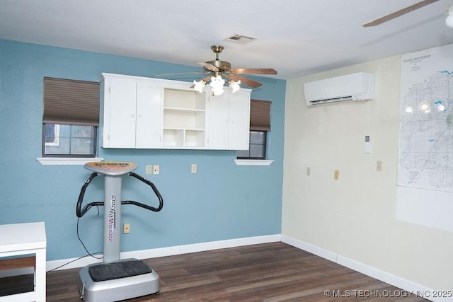 clothes washing area featuring ceiling fan, dark hardwood / wood-style flooring, and a wall unit AC