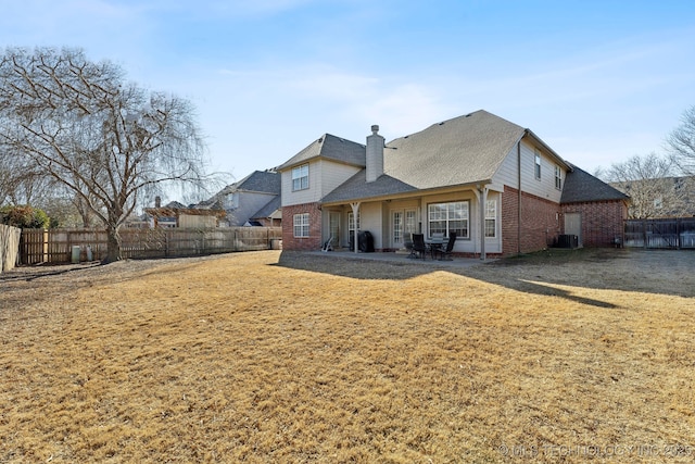 back of house featuring central AC unit and a lawn