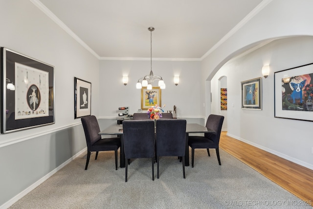 dining room with an inviting chandelier, crown molding, and wood-type flooring