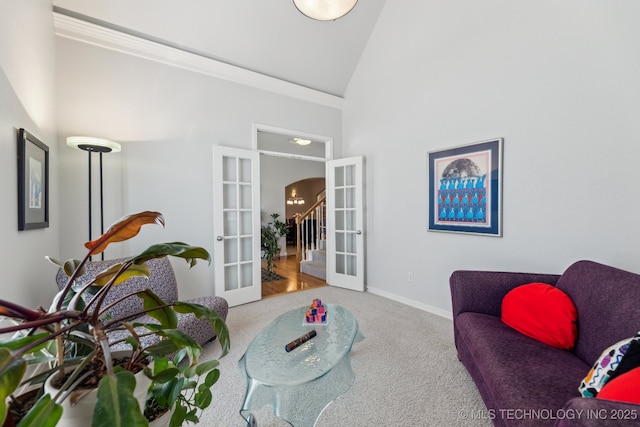 sitting room with carpet floors, high vaulted ceiling, and french doors